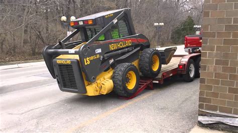 loading skid steer onto trailer|securing skid steer on trailer.